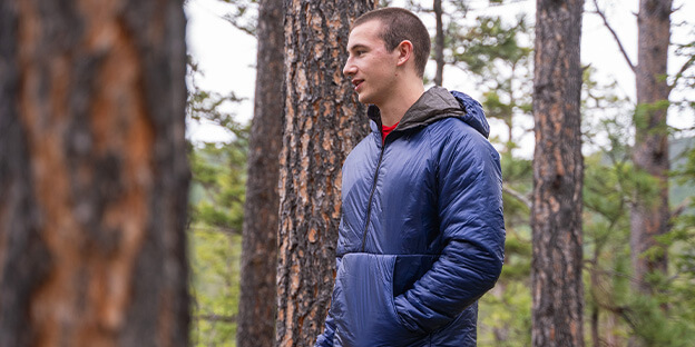 a man wearing a blue torrid pullover in nature