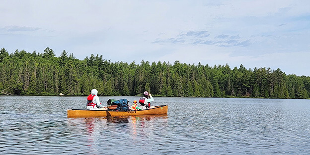 a family in a canoe paddling on a lake